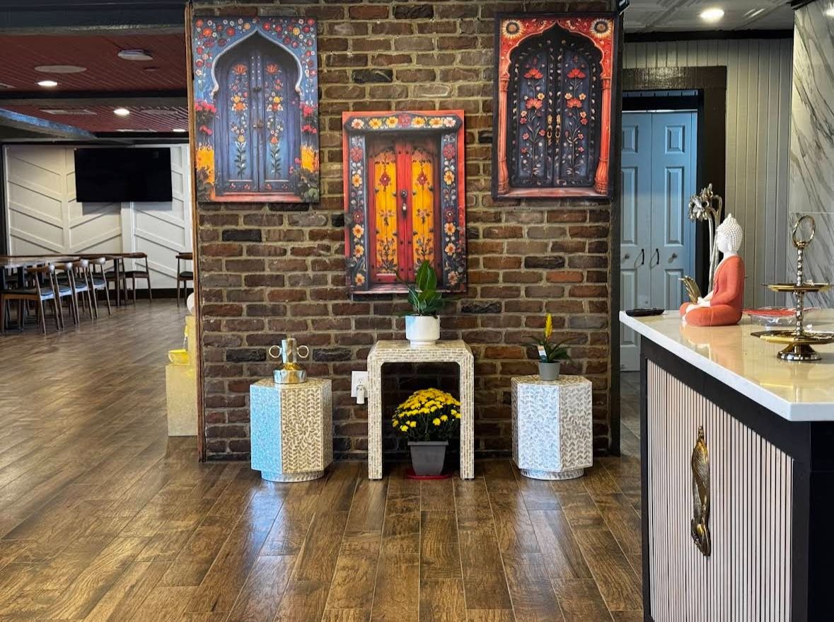 Restaurant interior with exposed brick wall and traditional Indian artwork